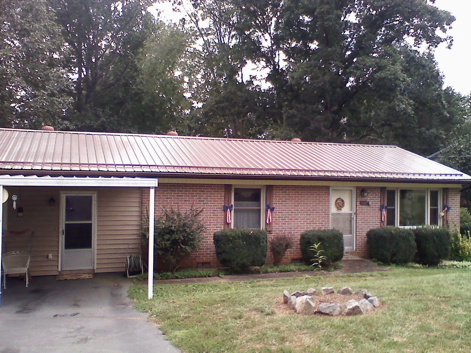 Bronze metal roof and carport on a brick ranch home — Roof Repair work by our crew in Meadow Grove