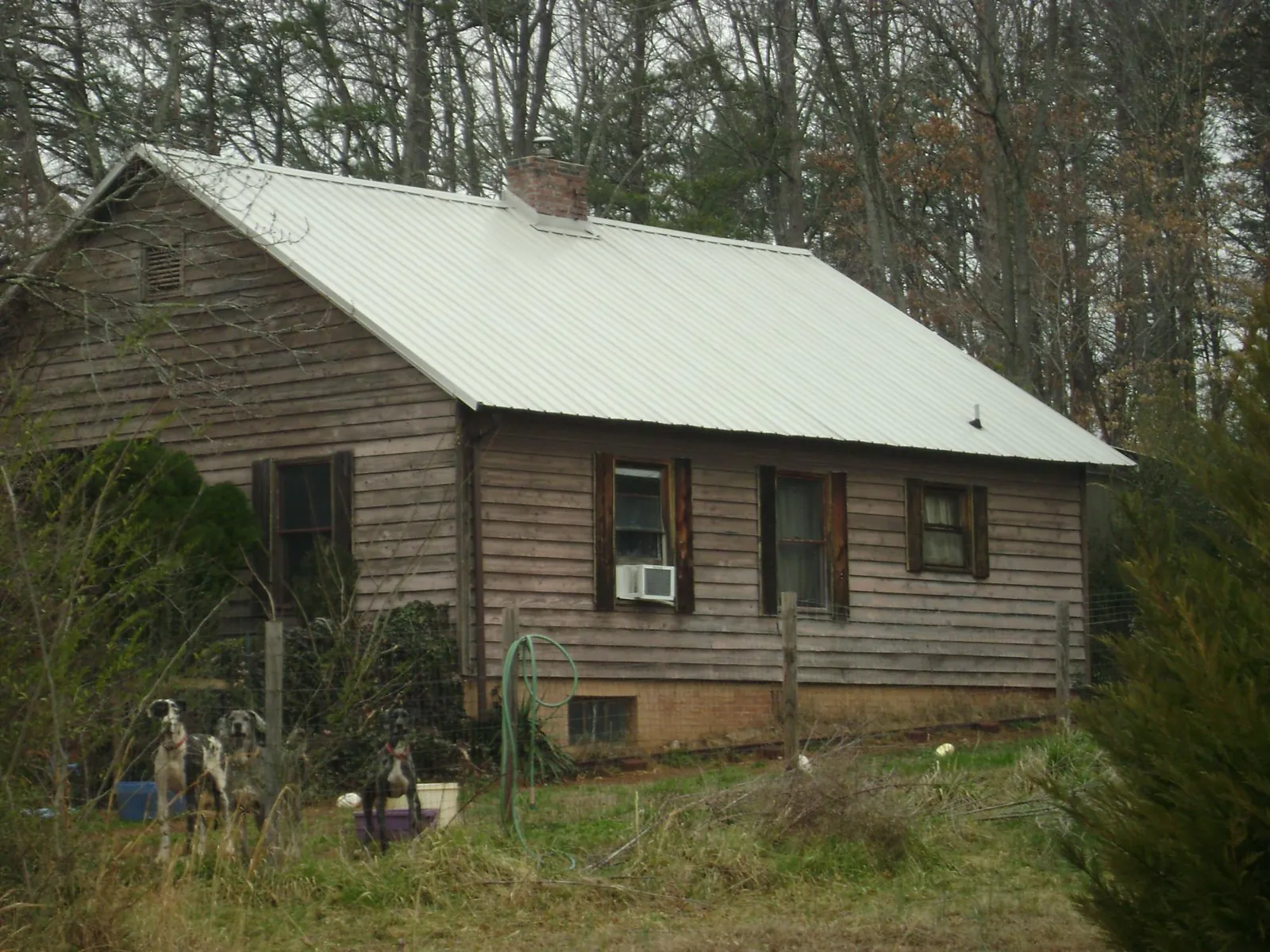 White metal roof on an old wood sided farmhouse, from a Metal Roof Installation job in Meadow Grove